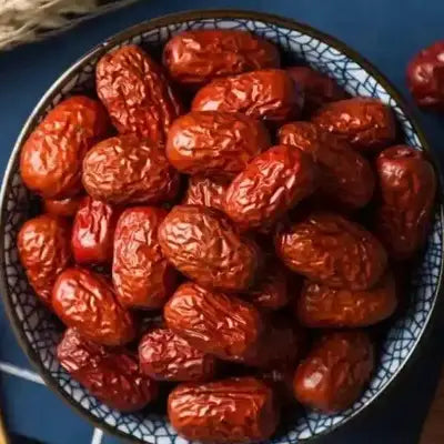 Bowl of dried red dates in herbal tea for stomach health during golden hour