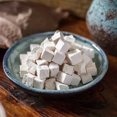 Pile of white cube-shaped herbal tea ingredients for improved sleep quality and pina date seed