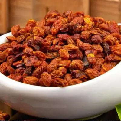 Dried reddish-brown berries for herbal tea to aid digestion during golden hour