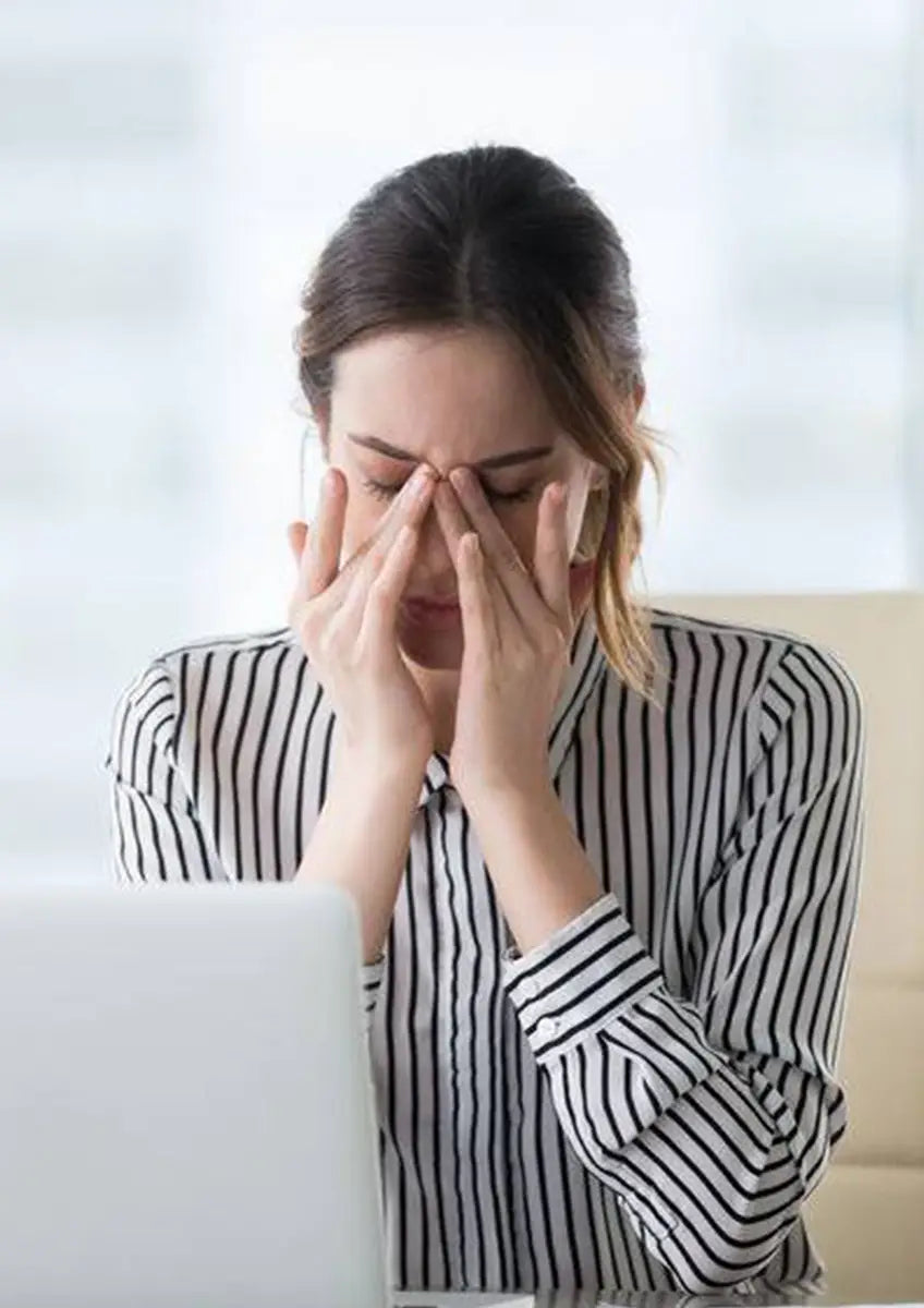 Stressed woman with hands on face enjoying Liver Detox herbal tea for abdominal fat reduction