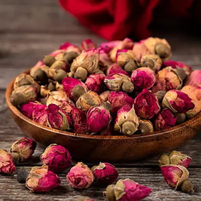 Dried rosebuds in a wooden bowl forSleep Tea herbal tea to support sleep quality and pina date seed