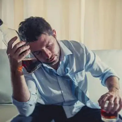 Drunk man with whiskey next to Health-Enhancing Herbal Tea featuring Hovenia Dulcis Thunb, tangerine peel, and volatile oils