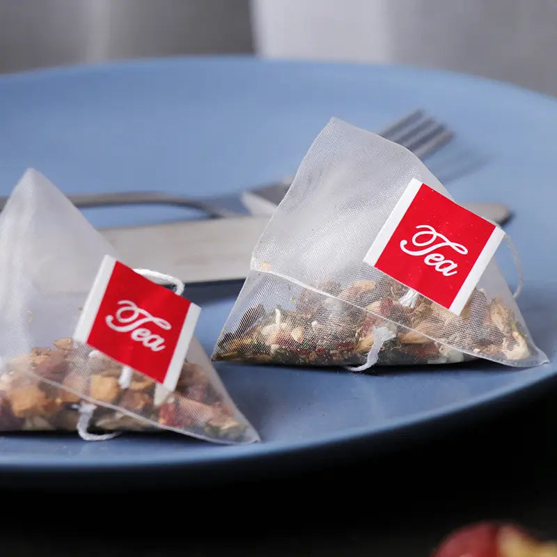 Two pyramid herbal tea bags from Stomach Tea for health during irregular diet and golden hour