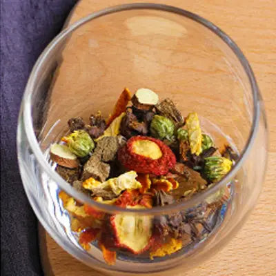 Glass bowl with dried herbs including Hovenia Dulcis Thunb, tangerine peel, and volatile oils for health tea
