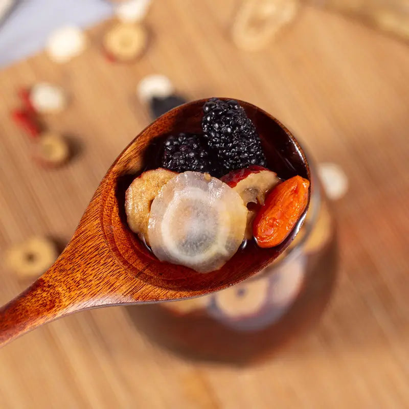 Wooden spoon holding dried fruits for kidney health and renal protection in herbal tea