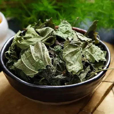 Dried green leaves in a bowl for Gout Tea Herbal Tea with poria cocos and antioxidant properties