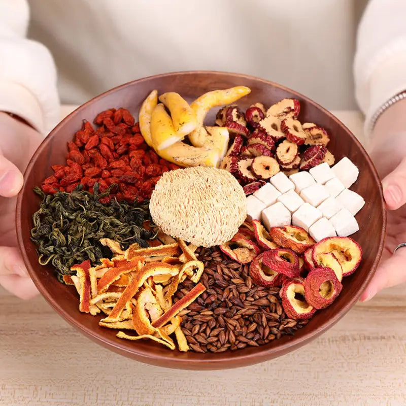 Wooden bowl with dried herbal tea ingredients ideal for stomach health during golden hour