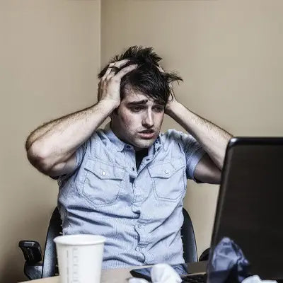 Frustrated man with hands in hair enjoying Stomach Tea herbal tea during golden hour for irregular diet relief