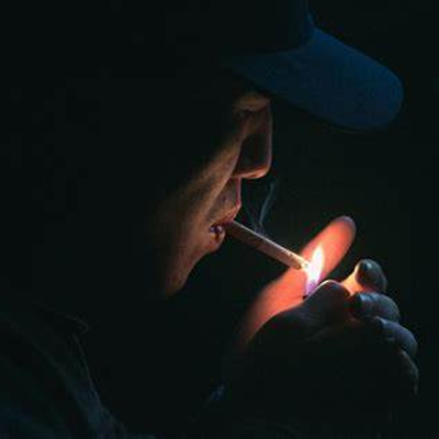 Person lighting cigarette with health-enhancing herbal tea featuring Hovenia Dulcis Thunb Tangerine Peel volatile oils