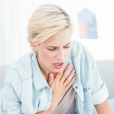 Distressed woman clutching chest with Red Bean Barley Tea supporting detox and herb tea for detox