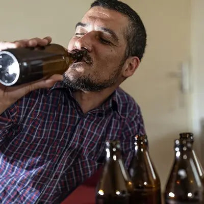 Man drinking beer with herbal tea during golden hour for irregular diet health benefits