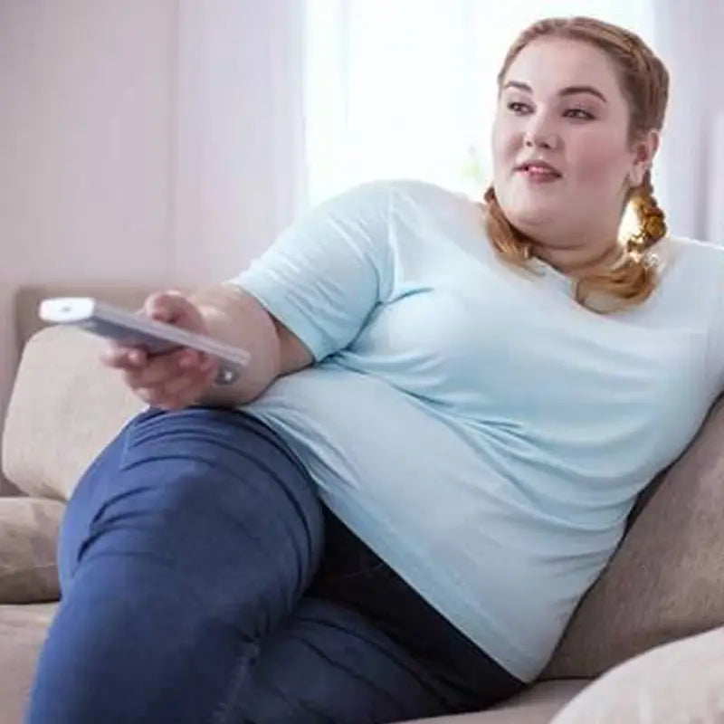 Overweight woman with remote during golden hour, promoting intestinal motility with lotus leaf herbal tea