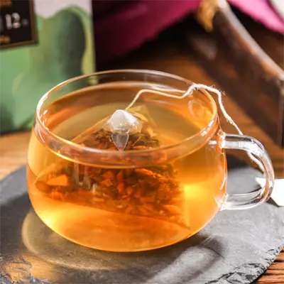 Glass teacup with herbal tea bag promoting intestinal motility during golden hour