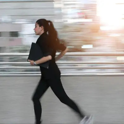 Businesswoman running with a folder during golden hour promoting herbal tea for irregular diet