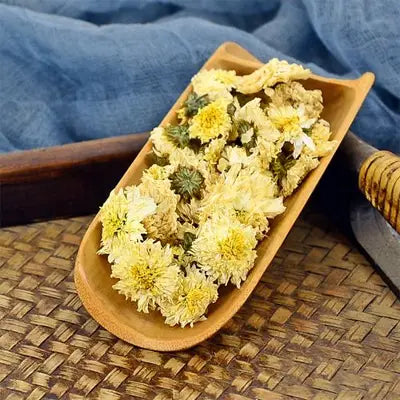 Dried chrysanthemum flowers in wooden scoop for Health Tea with hovenia dulcis thunb and tangerine peel